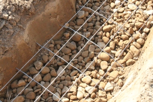 The trench ready for the pour with gravel base and old fencing used for reinforcement of the concrete base